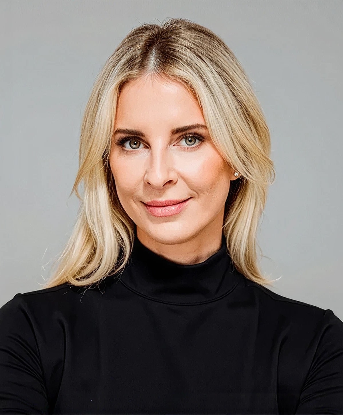 Smiling woman with blonde hair in black top.