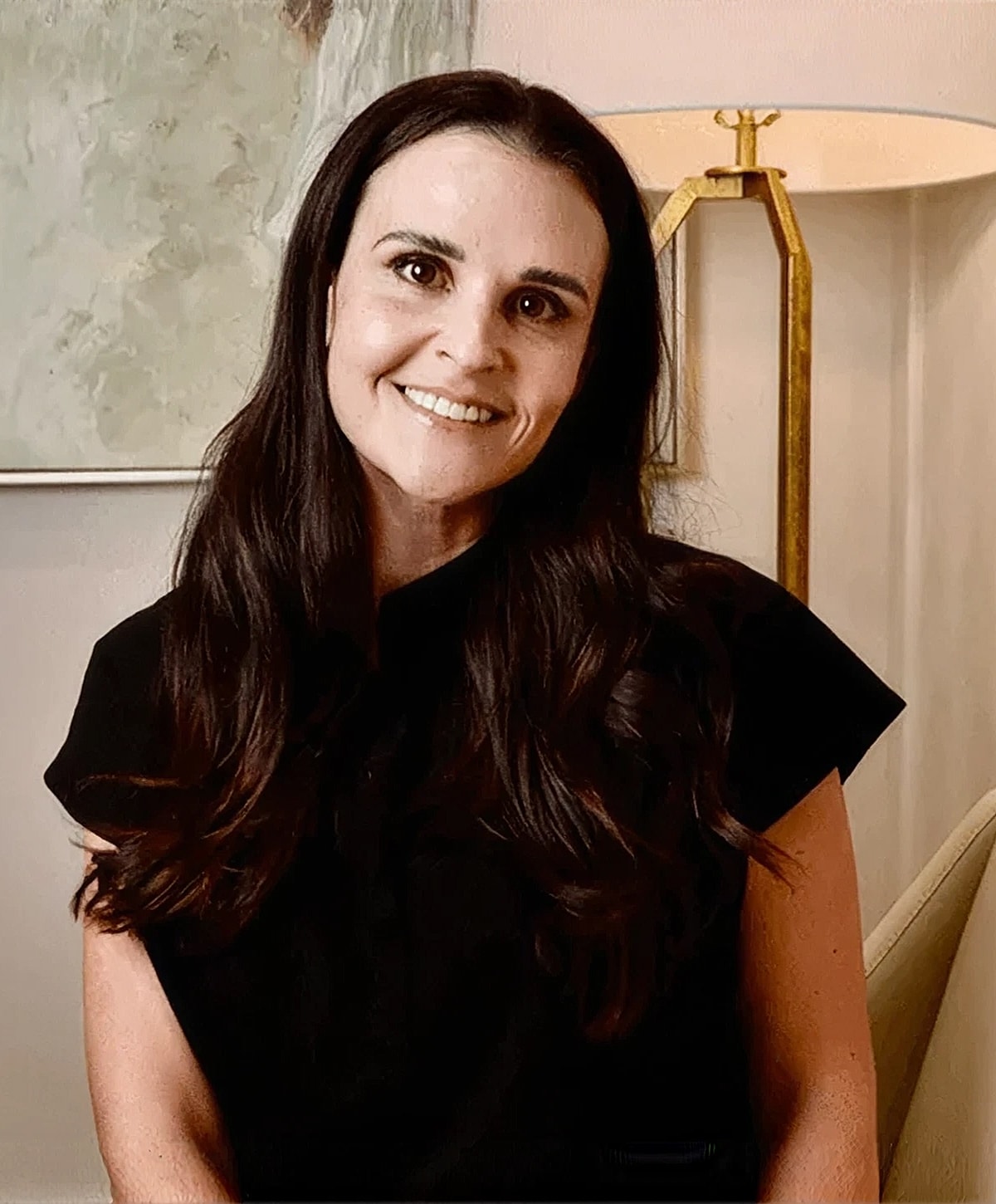 Smiling woman in a black shirt indoors.