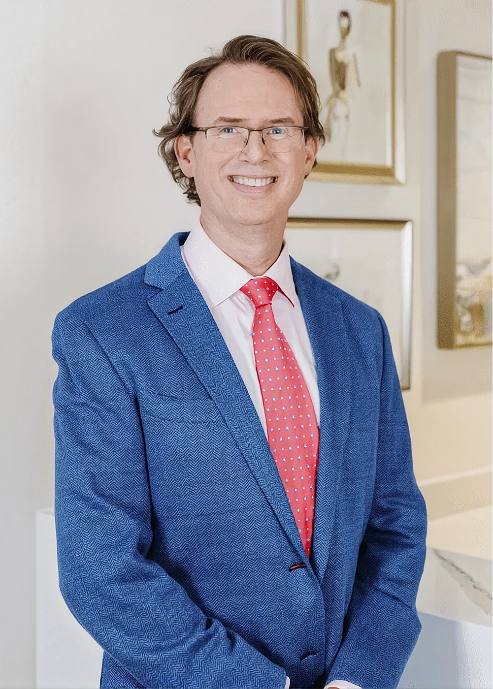 Charlotte, NC plastic surgery model in blue suit and pink tie, smiling.