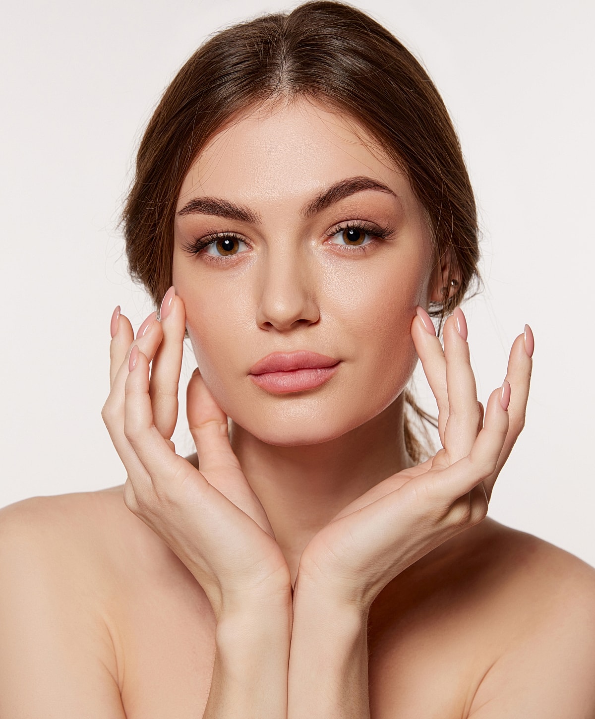 Charlotte, NC Fillers model showcasing skincare with hands on face.