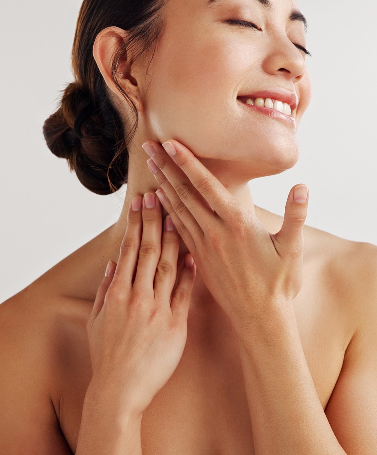 Charlotte, NC Fillers model gently touching her neck and smiling.